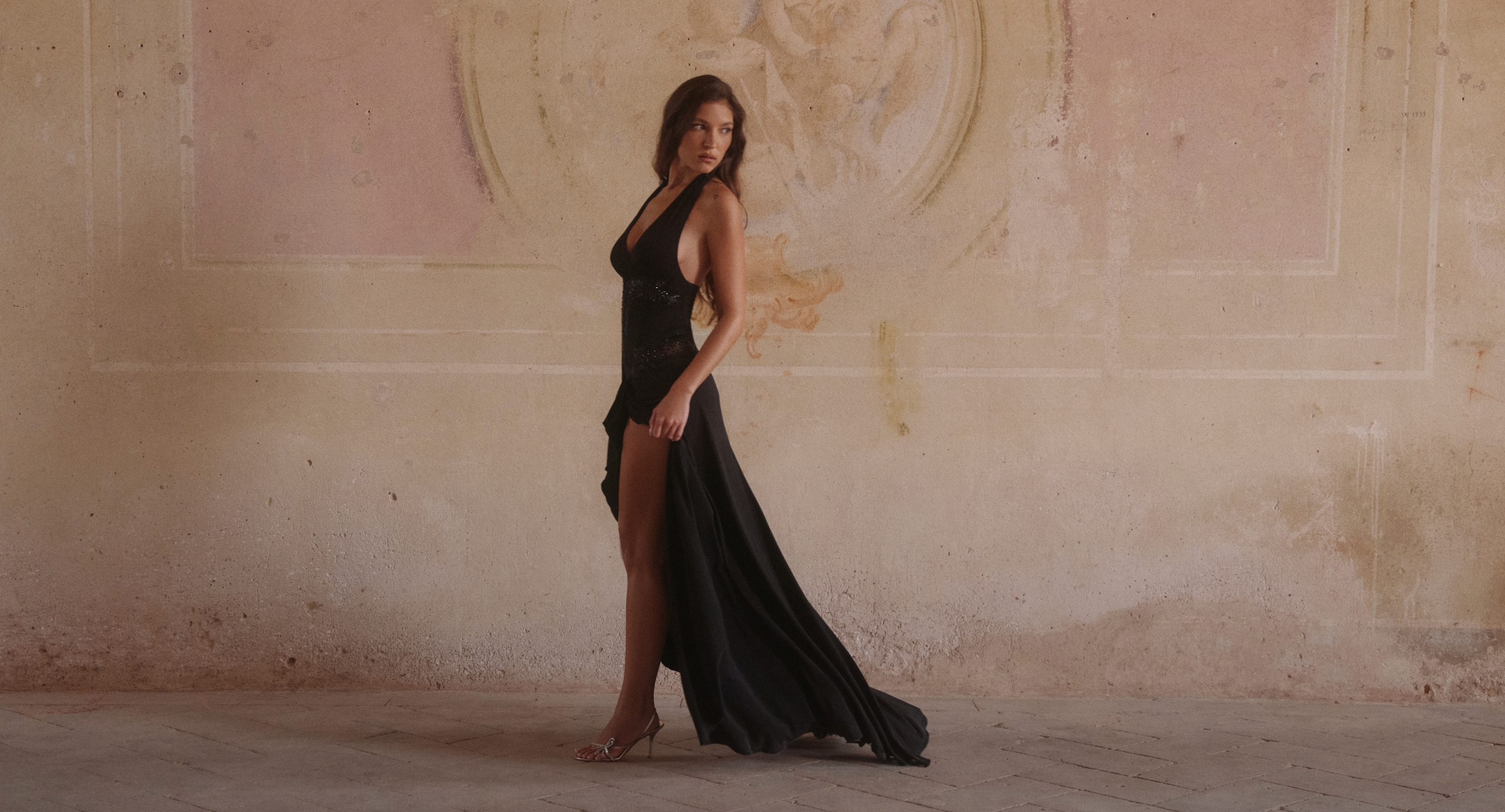 Side view of model walking in the Natalina Black Jersey Embellished Maxi Dress